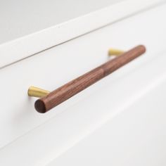 a wooden handle on a white cabinet door