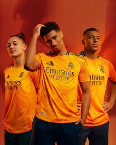 two soccer players are posing for the camera in front of an orange background with their hands on their head