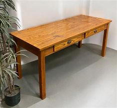 a wooden table sitting next to a potted plant