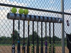 several tennis balls are sitting on top of the rackets in front of a fence