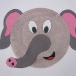 a paper plate with an elephant on it's face and pink nose, sitting in front of a white wall