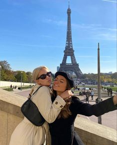 two women taking a selfie in front of the eiffel tower