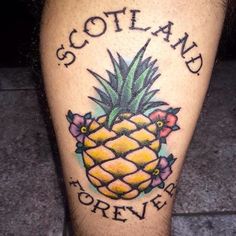 a tattoo on the leg of a man with a pineapple