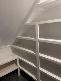 an empty room with white shelving in it