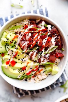 a white bowl filled with rice, cucumber and tomatoes on top of a table