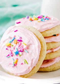 the best sugar cookies with pink frosting and sprinkles are stacked on top of each other