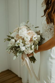 a bride holding a bouquet of flowers in her hand