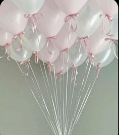 a bunch of pink and white balloons tied together