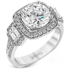 a white gold ring with an oval cut diamond surrounded by baguetts and round brilliant diamonds