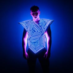 a man is standing in front of a blue background wearing a light - up shirt