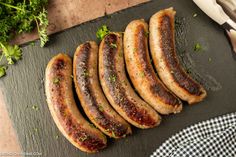 several sausages on a cutting board with parsley