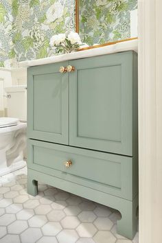 a bathroom with a green cabinet and white toilet