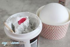 an ice cream cup with a spoon in it sitting next to a container of yogurt