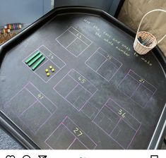 a blackboard with colored pencils on it next to a basket and other items