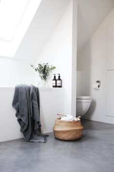 a bathroom with white walls and grey flooring