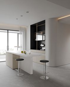 an empty kitchen with two stools in front of the counter top and large windows