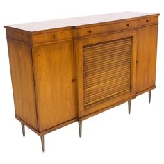 an old wooden sideboard with shutters on the doors and legs, against a white background