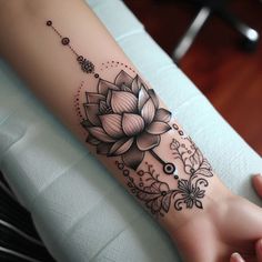 a woman's arm with a flower tattoo on it