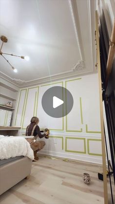 a woman sitting on top of a bed in a room with green and white walls