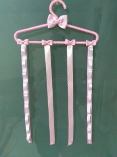 a pink bow tie hanger on a green wall