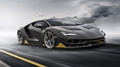 a grey and yellow sports car driving down the road with dark clouds in the background