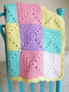 a crocheted blanket sitting on top of a blue chair