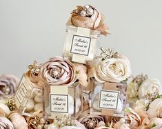 there are three small bottles with flowers in them on top of each other, and one has a label that says mother's day