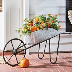 a wheelbarrow filled with flowers and pumpkins