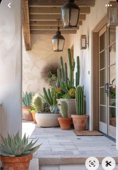 an image of a house with cactus plants on the front porch and side door area