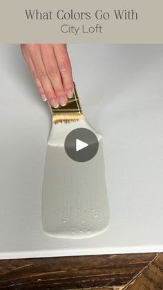 a person is using a brush to paint a white surface with gold trim on it