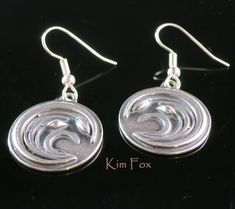 The Asian Wind Earrings come with a left and a right. The pattern is based on a Japanese Coat of Arms called a Mon. Grasses and flowers are shown blowing in the wind. The earring drops are 13/16 of and inch or 20mm around and hang and inch and a quarter or 32 mm from the top of the wire. They are light and comfortable to wear. Silver Engraved Brass Earrings, Engraved Silver Brass Earrings, Silver Symbolic Engraved Earrings, Silver Engraved Symbolic Earrings, Symbolic Engraved Silver Earrings, Silver Medallion Brass Earrings, Japanese Coat, Fox Design, Magnetic Clasp