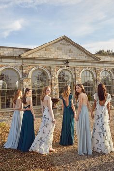 a group of women standing next to each other in front of a building