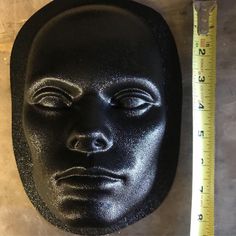 a black mask sitting next to a ruler