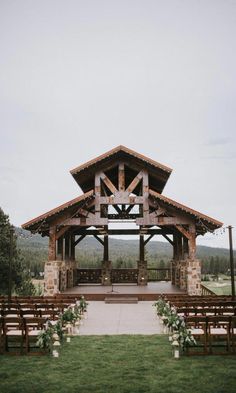 an outdoor wedding venue set up with wooden benches