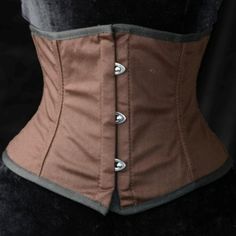 New This Corset/Waist Cincher Can Be Worn Over Any Blousy Top To Add A Bit Of Medieval Or Steampunk Flair To Your Renaissance Outfit, Whether A Maiden, Wench, Or Lass. Great For Halloween And Cosplay. This Corset Has A 3 Hook Front With Gromet Laced Back Tie And An Inner Back Modesty Flap. Steel Metal Boning- 100% Cotton Solid Medium Brown Color With Black Trim- Brown Cotton Canvas Inner Lining And Black Lacing Cord. Silver Metal Hardware. (Please Note Back Photos Show The Same Corset But In Lig Brown Underbust Corset For Costume Party, Fitted Brown Corset For Cosplay, Brown Fitted Corset For Cosplay, Gothic Brown Corset For Costume, Brown Gothic Corset For Costume, Brown Corset For Cosplay, Brown Overbust Corset For Costume, Vintage Brown Corset For Larp, Steampunk Brown Underbust Corset