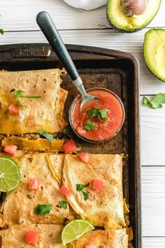 mexican quesadilla on a baking sheet with salsa and avocado