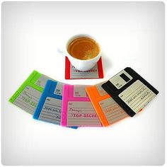 there are several floppy disk labels next to a cup of coffee