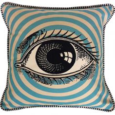 a blue and white striped pillow with an eye drawn on the front, in black ink