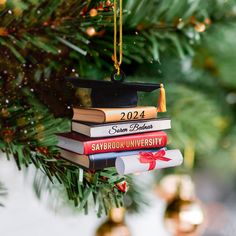 a christmas ornament hanging from a tree with books stacked on top of each other