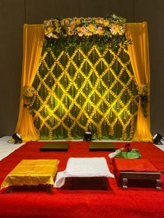 a red carpet with yellow drapes and flowers on it