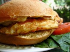 a chicken sandwich on a plate with tomatoes and lettuce