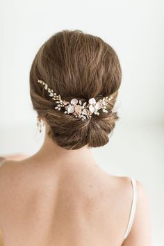 the back of a woman's head wearing a hair comb with flowers on it