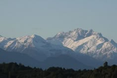 the mountains are covered in snow and trees