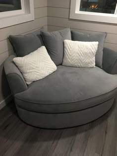 a grey couch with two white pillows on it