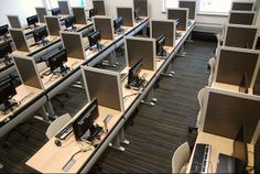 rows of computer desks with computers on them