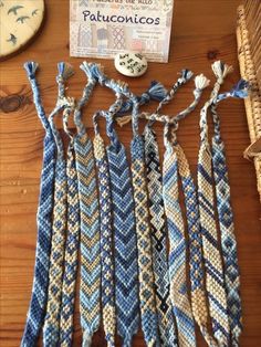 several pieces of blue and white knitted fabric on a wooden table next to a button