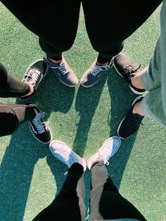 four people are standing in a circle on the grass