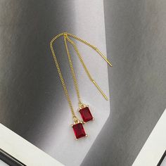 These Ruby Red Teardrop Crystal Thread Earrings are a dazzling combination of elegance and simplicity. Featuring striking ruby red teardrop crystals delicately suspended from slender chains, they provide an eye-catching pop of color and a subtle sparkle. Perfect for any occasion, they effortlessly enhance both casual and formal looks with their timeless appeal. Measurements: The total length from the top of the hook to bottom - 3.74 inches (95 mm) approximately. Crystals: 8 mm x 5 mm These earri Elegant Red Drop Earrings, Elegant Red Drop Crystal Earrings, Red Minimalist Dangle Earrings, Elegant Red Crystal Earrings, Minimalist Red Jewelry For Party, Minimalist Red Party Jewelry, Elegant Red Earrings With Ear Wire, Crystal Earrings Wedding, Red Thread