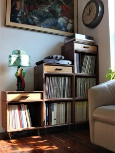 a living room filled with furniture and a painting on the wall above it's bookshelf