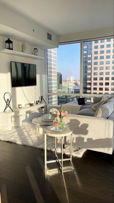 a living room filled with furniture and a flat screen tv mounted to the wall next to a window